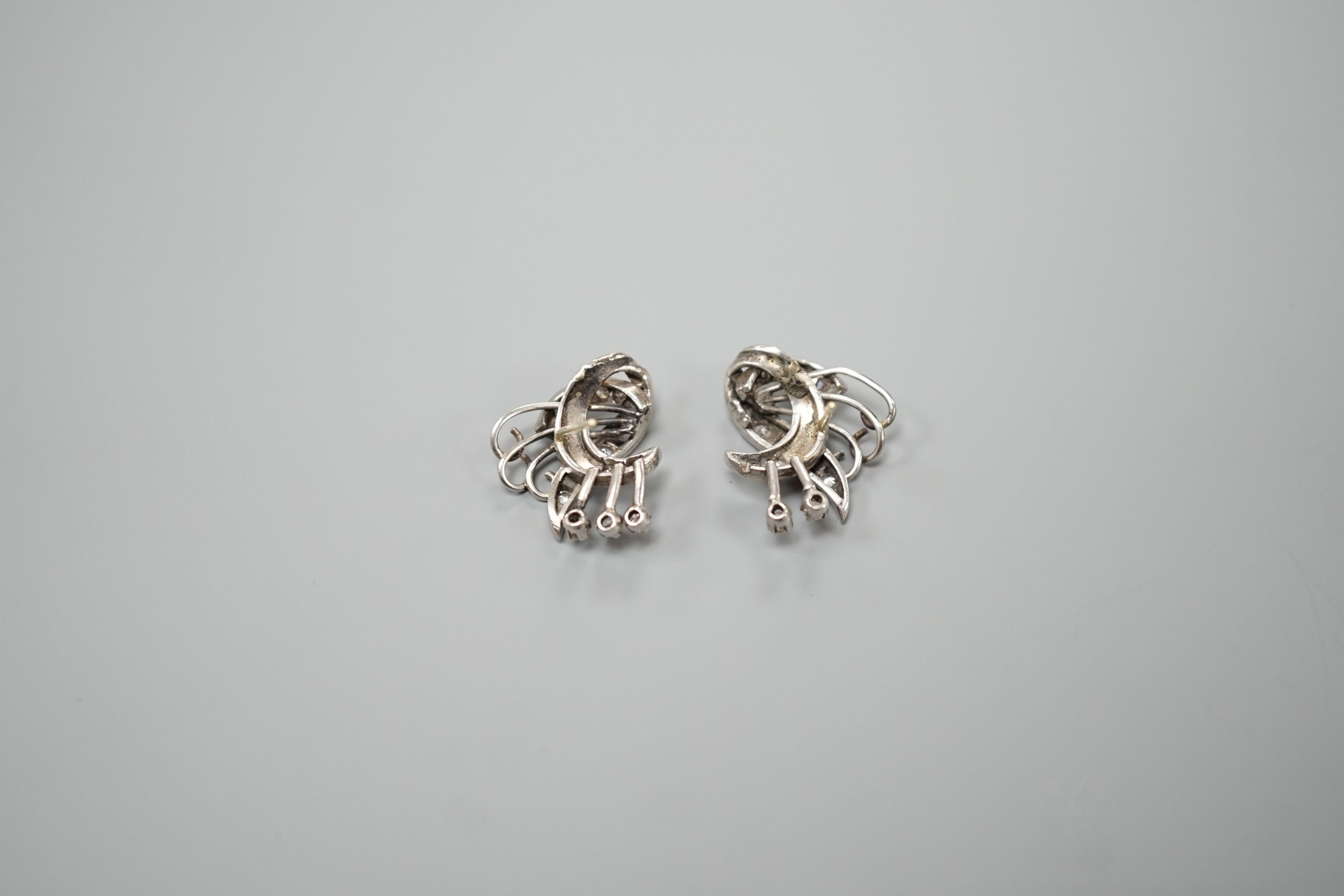 A pair of 20th century white metal and diamond cluster set fan scroll earrings(lacking butterflies), 15mm, gross weight 8 grams.
